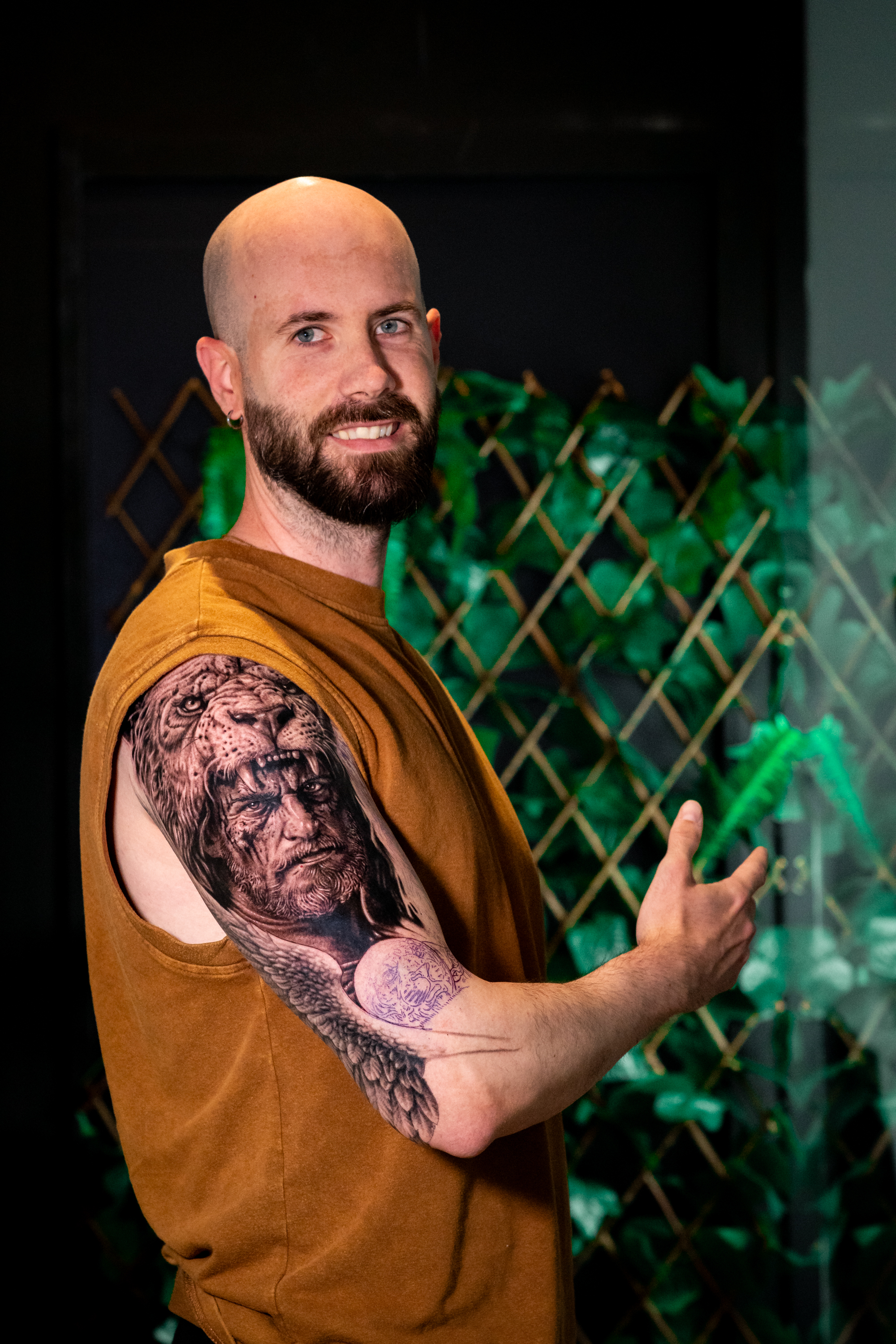 Tatuaje realista de león fusionado con retrato de guerrero en el brazo