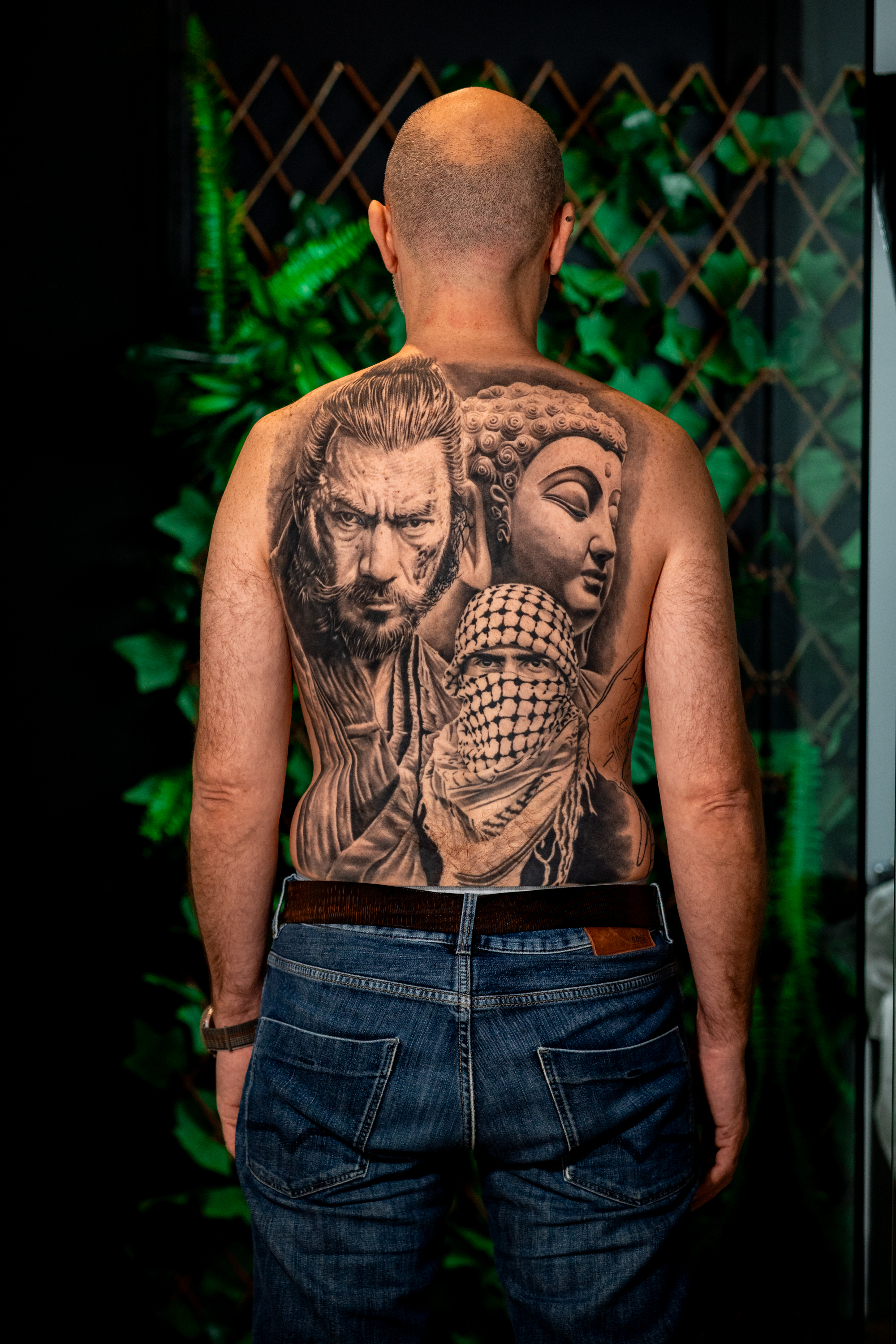 Tatuaje retrato de guerrero, hombre con kufiya y busto de Buda en la espalda