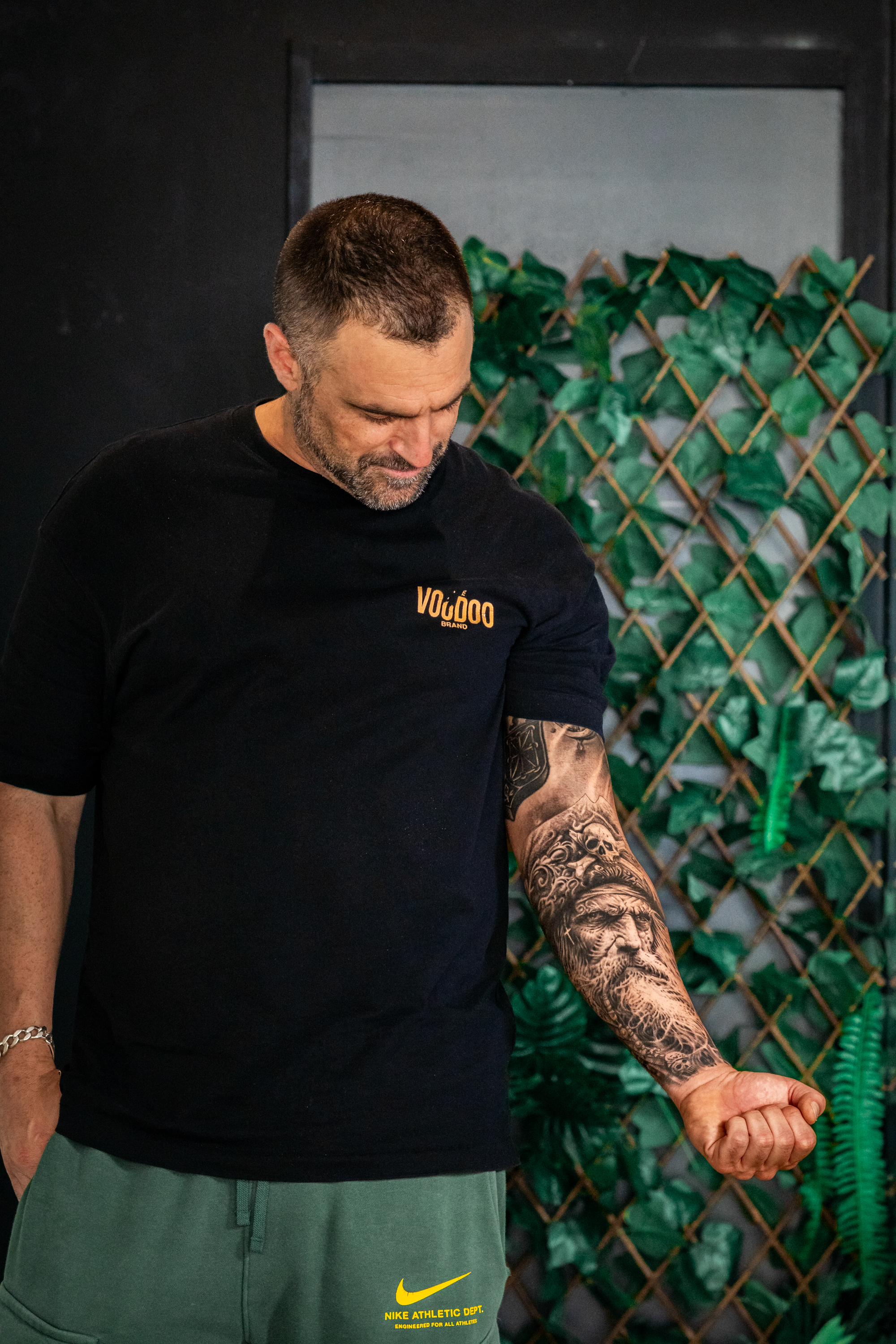 Tatuaje retrato realista de hombre con casco y calaveras en el antebrazo