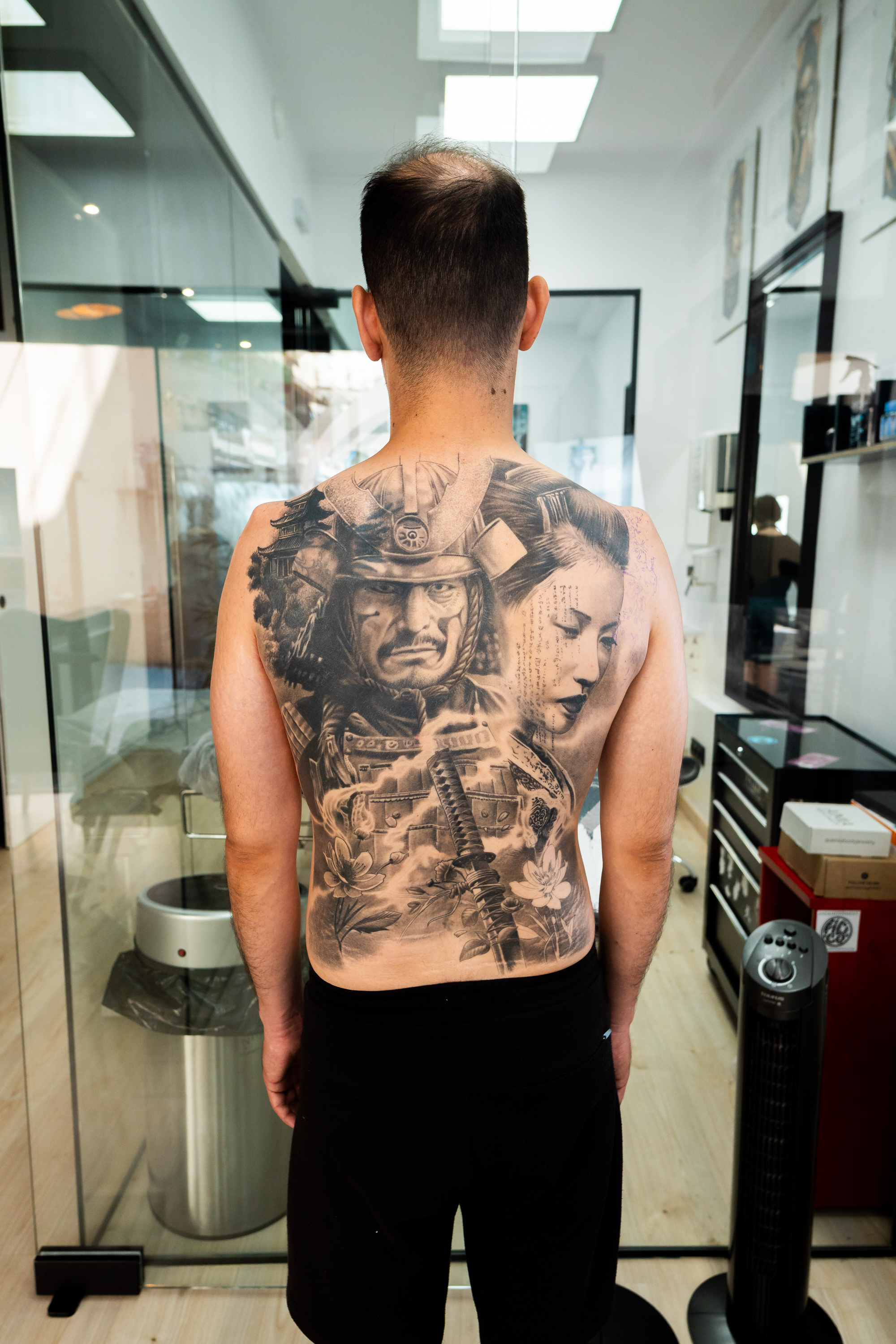 Tatuaje retrato realista de samurái y geisha cubriendo toda la espalda